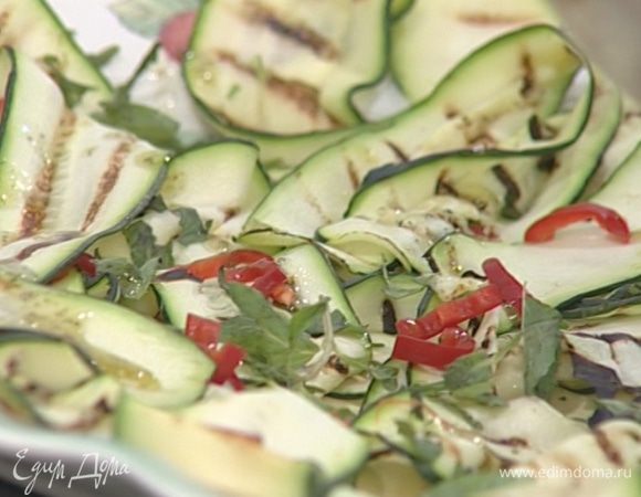 Выложить цукини на большое блюдо, присыпать измельченным перцем чили и листьями мяты, полить заправкой.