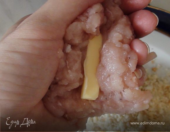 Взять в руку фарш для одной котлетки, сделать лепёшку, в центр положить кусочек масла и зажать со всех сторон.
