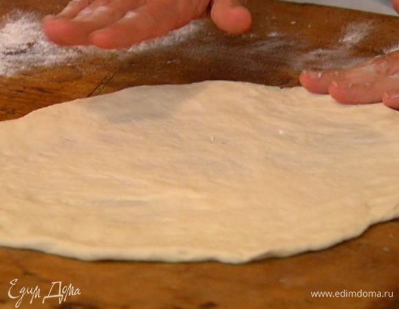 Раскатать тесто в тонкий пласт. Перевернуть противень вверх дном, присыпать его мукой и выложить на перевернутый противень раскатанное тесто.