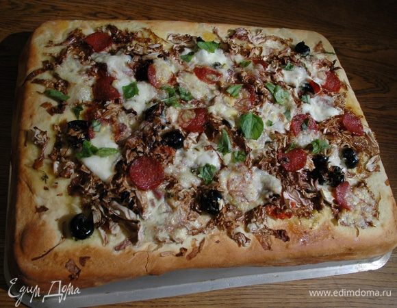 Смазать тесто оставшимся оливковым маслом, выложить оливки,  колбасу, радиккио, кружки моцареллы, полить заправкой с тимьяном. Выпекать пиццу в разогретой духовке 10–12 минут до золотистого цвета.