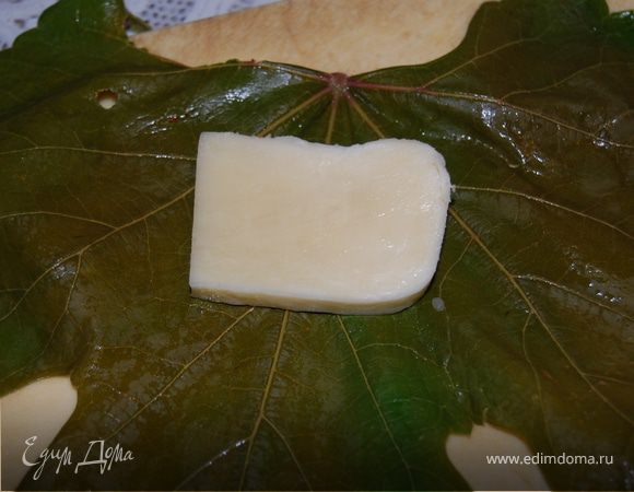 Сыр нарезала на небольшие квадратики, завернула каждый в виноградный лист, уложила в глубокую миску.