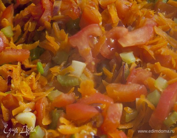 Высыпать в форму лук и чеснок, обжарить, затем добавить морковь, стебли сельдерея (листья пока оставить), помидоры и вино. Потушить несколько минут на сильном огне.