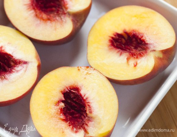 Персики разрезать пополам и, вынув косточки, уложить в керамическую посуду.