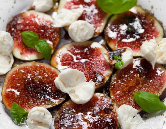 Полить салат заправкой, в которой мариновался инжир, и посыпать листьями базилика.