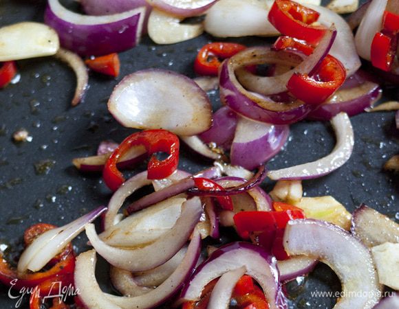 В этой же сковороде обжарить лук, чеснок и перец чили. Добавить нарезанные грибы, мясной маринад и тушить все вместе 5–7 минут.