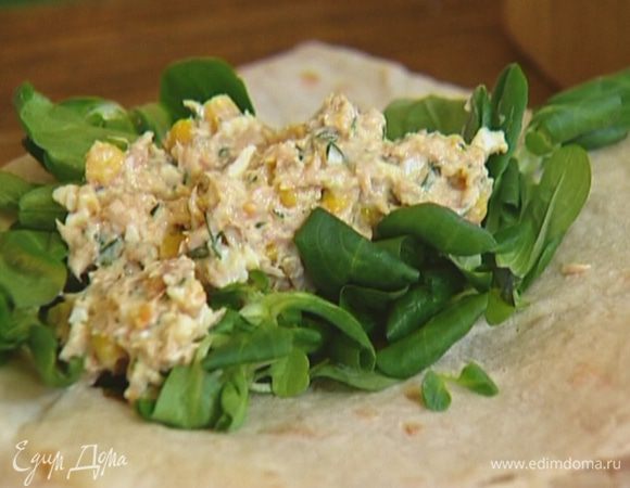 На край лаваша выложить листья салата, на них начинку из тунца.