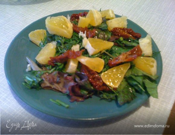 На тарелку выложить смесь зелени (листья крупные только рвать, не резать), мелко нарезать апельсин, томаты, сбрызнуть оливковым маслом и соусом бальзамическим. Можно посыпать поджаренными на сухой сковороде кунжутом.