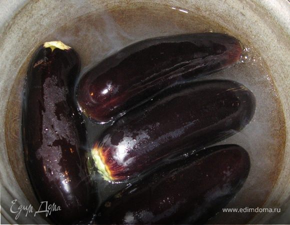 Баклажаны нужно отварить целиком (только "хвостики" отрезать) в соленой воде минут 15 - 20, но длительность варки зависит от их размера. Важно не переварить. У меня в данном случае они были не больше ладошки, потому их у меня 4 и варила я их 10 минут после того как закипели. Готовые баклажаны, переложить в раковину и разместив поверх доску нежно поприжимать руками - отжать и оставить.