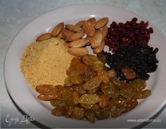 Засыпать рис равномерно поверх мяса, налить аккуратно по стенке горячей воды на 2 см выше уровня риса, посолить, добавить чеснок и специи. У меня были готовые специи для плова, два сорта кизила, изюм. Добавлять горох в плов мне не нравится, он придает мучнистый привкус, под руку попался миндаль и я его сыпанула тоже.