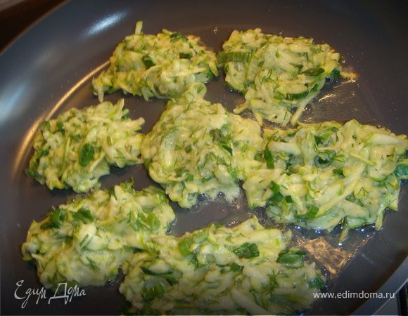 Сначала натираем кабачок на крупной терке, солим и отставляем в сторону – кабачок должен пустить сок, который нам не нужен. Впоследствии мы его сольем.
Запеченный чеснок растереть в ступке до кашицы. Зелень нарезаем мелко. Яйцо слегка взбиваем. Соединяем кабачок, зелень, яйцо, чеснок, добавляем пармезан, вымешиваем все хорошенько, добавляем муку. Консистенция должна получиться как на оладьи. Обжариваем на сковороде с одной стороны, переворачиваем, накрываем крышкой и на медленном огне доводим до готовности. 