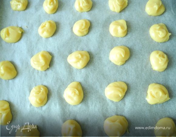 Можно использовать кондитерский шприц, я выкладываю массу кофейной ложечкой на бумагу для выпечки, уложенную на противень. Между пирожными нужно оставить место, так как при выпечке они увеличиваются в размере.
