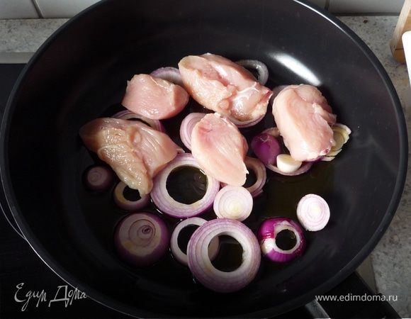 Лук режем кольцами. Куриную грудку на небольшие кусочки. Петрушку мелко рубим.
Ставим сковороду на маленький огонь. Выливаем оливковое масло, выкладываем лук и куриное филе.