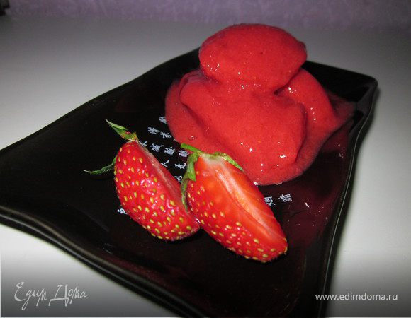 Клубнику порезать на четвертинки, посыпать сахаром, добавить воду или сок. Перемешать и дать постоять до растворения сахара. Как только сахар раствориться поместить клубнику в блендер. Выложить пюре в пластмассовый контейнер и поставить в морозильник. Как только сорбе станет замерзать, нужно будет взбивать вилкой каждые 30 минут. 