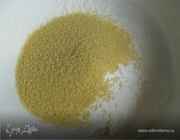 Разогреть духовку до 190 °С. Дно и бортики формы для выпечки диаметром 23 см смазать растительным маслом. Положить на дно круг, вырезанный из пергамента. Также смазать его растительным маслом.
В миску просеять муку, соль и разрыхлитель. Добавить кускус.