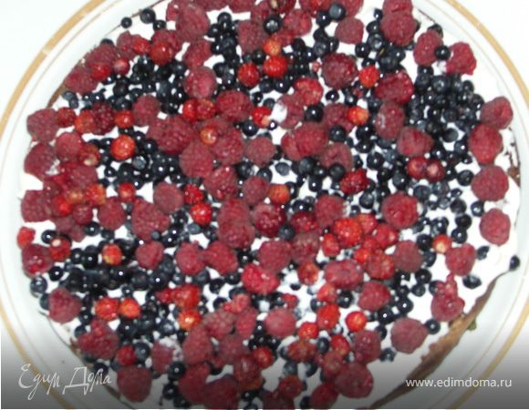 А теперь оперативненько начинаем собирать наш торт.На нижний пропитанный слой выкладываем густо крем и половину ягод предназначенных для начинки.