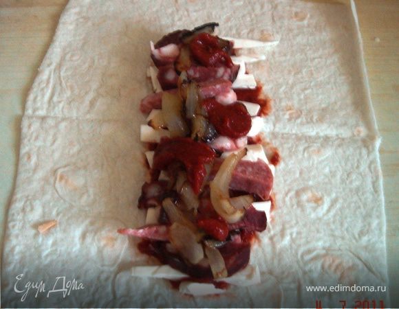 Разрезать лаваш на прямоугольные порции. У меня вышло 8 лавашиков. Распределить по лавашу начинку в последовательности: соус-сыр-колбаса-лук-соус и завернуть изделие.