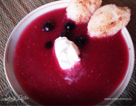 В суповую тарелку налить суп, добавить несколько ягод, сметану или сливки. Клецки положить на край тарелки.