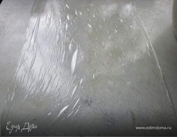 Сбрызнуть стол водой и постелить на него пищевую пленку. Очень удобно потом перекладывать на противень, но может кто-то по своему это делает.