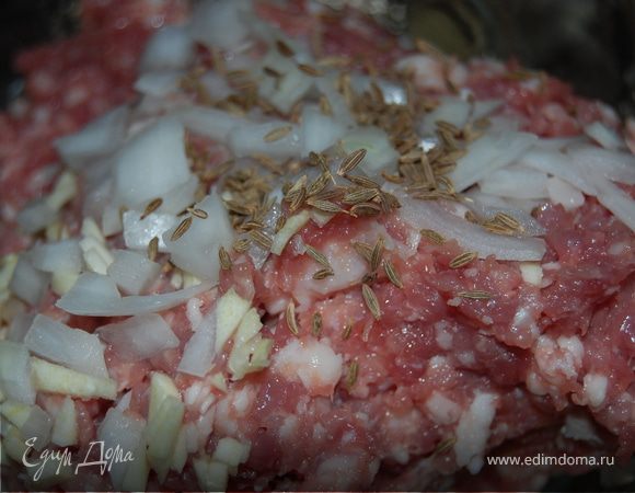 Лук мелко-мелко, на сколько это возможно, я рублю отдельно, так же поступаю с чесноком, потом смешиваю это с мясным фаршем. Фарш солю, перчу черным перцем и добавляю зиру – она придаст неповторимый аромат и восточный колорит нашему блюду. Можно плеснуть буквально 1 столовую ложку водички, для сочности.