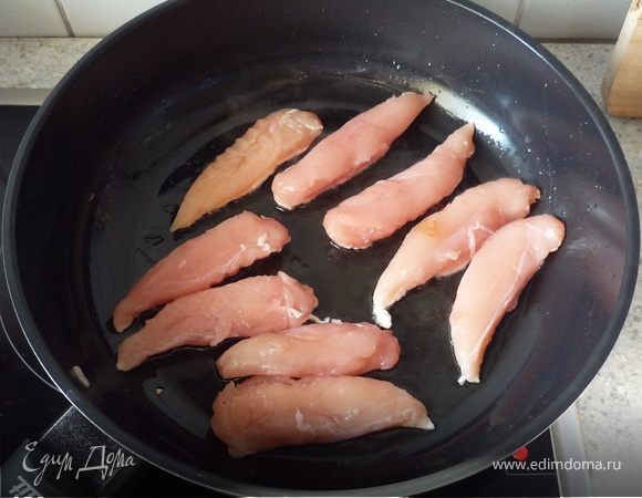 Филе нарезать на кусочки толщиной ок. 1 см. Достать из сковороды лук и обжарить в оставшемся масле курицу с двух сторон.