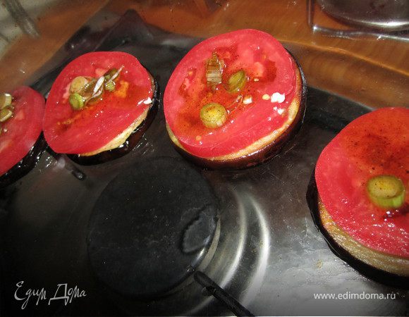 Выложить баклажаны, на них помидоры, полить соусом 