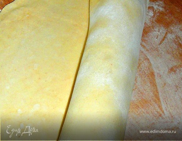 Тесто расскатать,перенести его в форму,удобнее это будет сделать накрутив его на скалку.