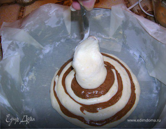 Форму застелить бумагой для выпечки и смазать сливочным маслом (так легче бисквит отстает от бумаги). Диаметр моей формы 25 см.
В форму выкладывать поочередно ложку белого теста, ложку шоколадного.
Выпекать при 200 градусах примерно 1 час. (готовность проверять зубочисткой).