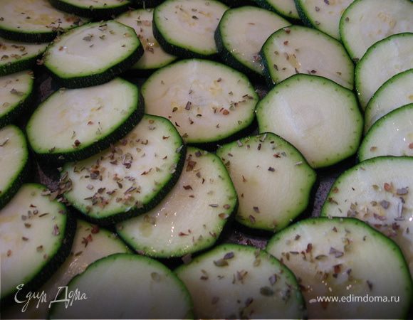 Выкладываем слой цукини. Немного поливаем маслом и присыпаем специями.