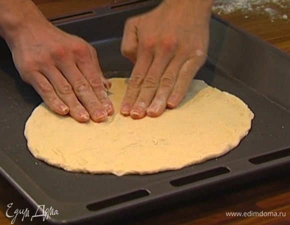 Тесто разделить на 2 части, из каждой сформировать лепешку и слегка растянуть их руками.
