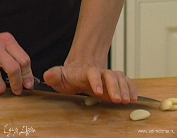 Чеснок почистить и раздавить плоской стороной ножа.  