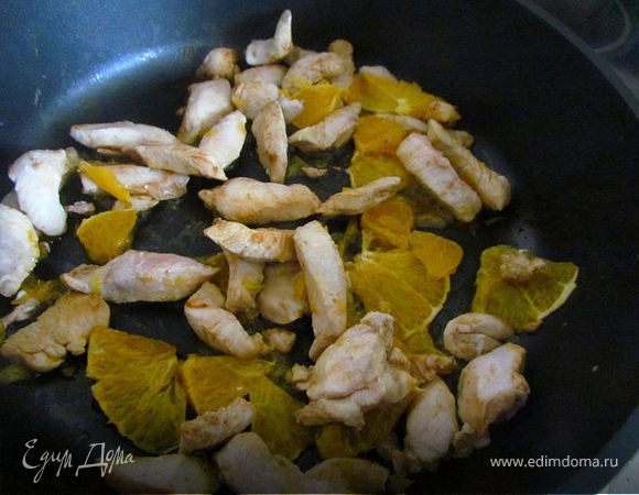 Затем выжать в сковороду сок половины большого апельсина. Оставшуюся половину апельсина очистить, поделить на маленькие сегменты и добавить к курице. Убавить огонь.