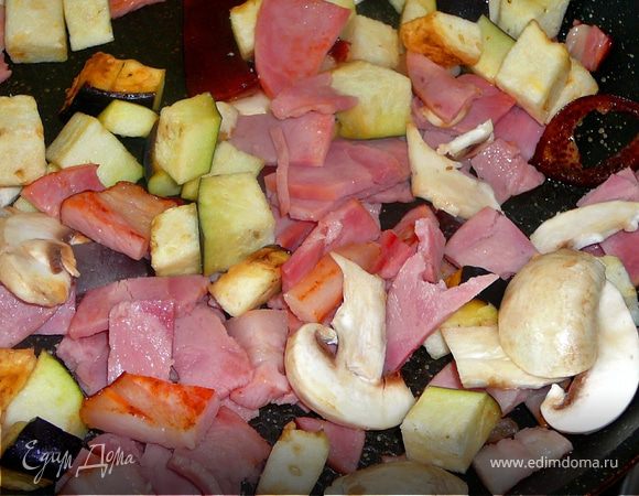 Лук порезать тонкими полукольцами,добавить к бекону,грибы вымыть обсушить,нарезать тонкими полосками и отправить на сковороду.Чеснок мелко порубить,баклажан нарезать не крупными кубиками,отправить так же на сковороду.Все жарить на среднем огне переодически помешивая,минут 10.