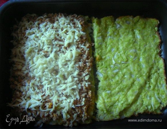 Достаем пирог- запеканку, отмеряем середину , разрезаем и отправляем в духовку еще на 10 минут. Опять достаем и выкладываем на одну из половинок тушеные овощи-фарш и трем сверху сыр