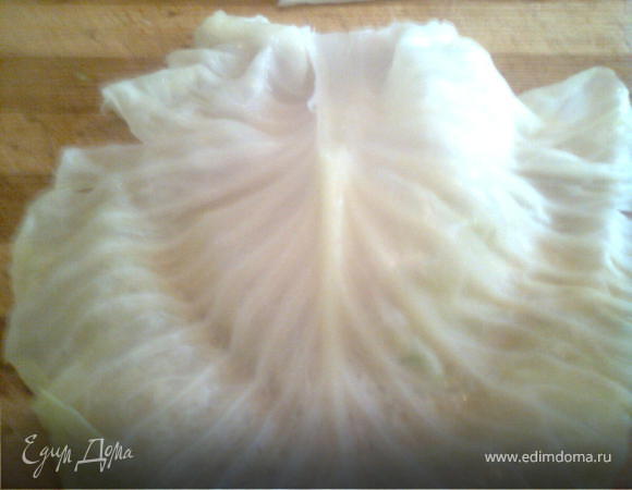 кладём на доску лист капусты а на неё немного готового фарша и заварачиваем