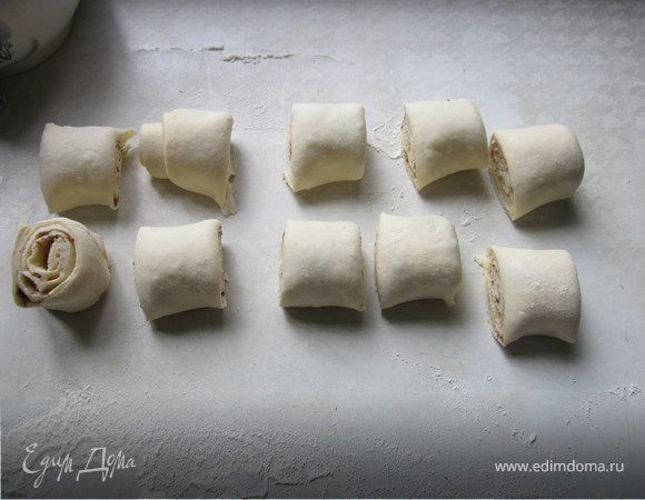 Пластинку теста раскатать, смазать растительным маслом без запаха (можно растопленным сливочным), слегка посыпать сахаром и корицей. Свернуть тесто в рулет и разрезать. У меня получилось 10 штук по 2-2,5 см.