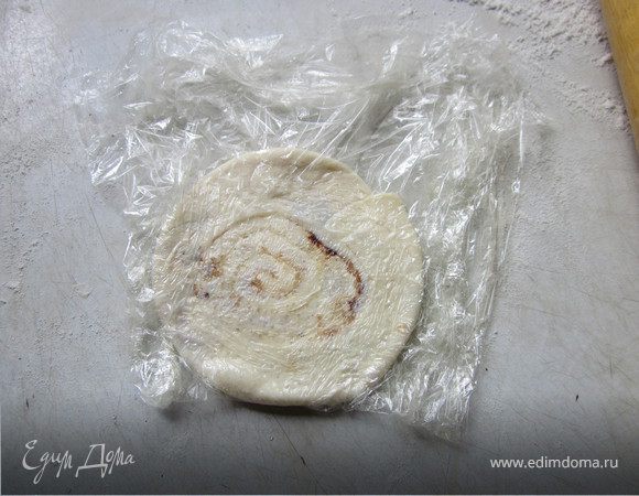 За тем положить заготовку между пищевой пленкой и раскатать в маленький блин.
