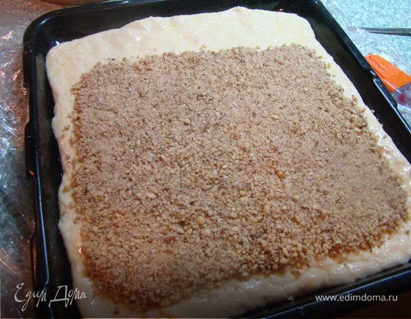 На противень выкладываю тесто и распределяю его равномерно по всей ширине противня. Смазываю тесто топленым маслом. Выкладываю сверху начинку. Закручиваю рулет и снова смазываю топлены маслом.  