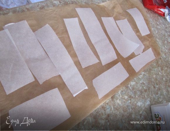 Я решила попробовать сделать украшение из белого шоколада. 
Для этого нужно...
Нарезать полосочки из пергаментной бумаги
