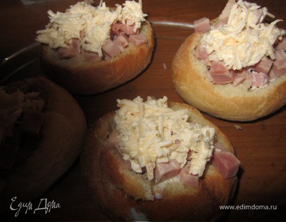 Выложить часть сыра на булочки.