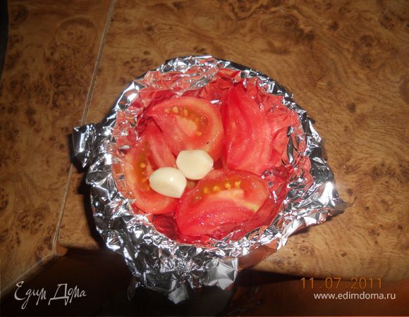 помидор очищаем от кожуры режем на 4 части, из фольги делаем чашеку, туда кладем помидор и честнок, и запекаем в духовке при 200 гр, в течении 20 мин, 