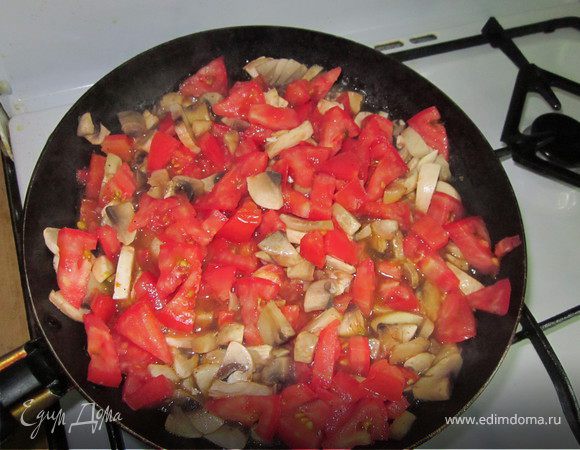 Шампиньоны и томаты порезать и выложить на предварительно разогретую с растительным маслом сковороду. Посолить, поперчить и жарить пока влага не испарится.
