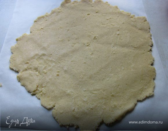 Постелить на стол бумагу для выпечки и на нем раскатать тесто (с пергамента очень удобно переносить тесто в форму, нужно просто будет перевернуть)