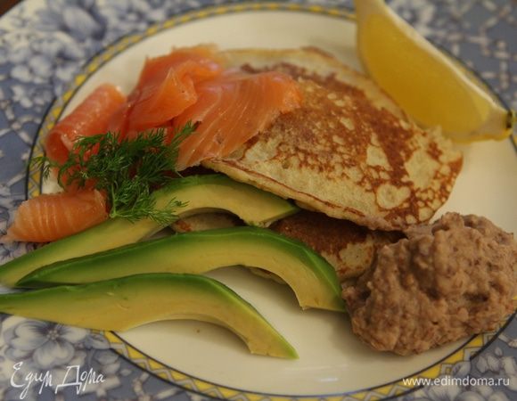 Подавать блины с авокадо и семгой, добавить в каждую тарелку немного хумуса и дольку лимона, посыпать укропом.
