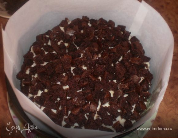 Торт помещаем в разъемную форму, изнутри бортик покрываем бумагой. Выливаем крем сверху на торт. отправляем в холодильник для застывания.