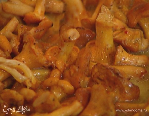 Вынуть чеснок, выложить в сковороду лисички, перец чили и горсть измельченной петрушки, посолить и поперчить, жарить на сильном огне 4–5 минут.