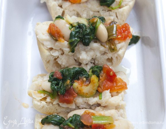 В большую жароупорную форму выложить половину хлеба, полить 3 ст. ложками оливкового масла, сверху залить супом, посыпать неразмятой фасолью, поперчить и посолить, накрыть хлебом, опять полить хлеб оливковым маслом и добавить немного воды, в которой варились шпинат и щавель.