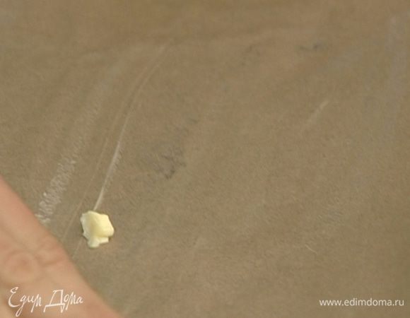 Выстелить противень бумагой для выпечки, смазать ее сливочным маслом.