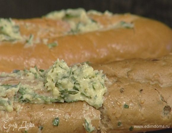 В хлебе сделать глубокие надрезы по диагонали, но при этом не прорезать насквозь. В местах надрезов начинить хлеб заправленным маслом. Не жалейте масла!