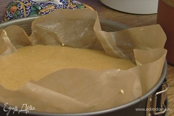 Разъемную форму выстелить бумагой для выпечки, смазать ее оставшимся сливочным маслом и вылить тесто в форму.