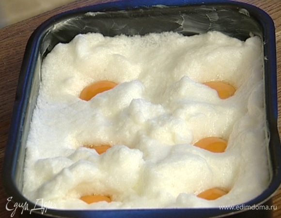 Выложить в получившиеся углубления желтки.  Поперчить, слегка присыпать натертым сыром, сверху положить по небольшому кусочку масла. На самом нижнем уровне разогретой духовки запекать яйца 15–20 минут. 